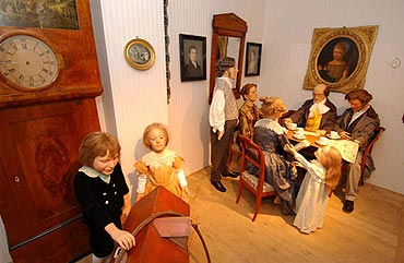 Szene in der Ausstellung: Eine brgerliche Familie sitzt gemeinsam an einem Kaffeetisch. Die Kinder spielen im Vordergrund