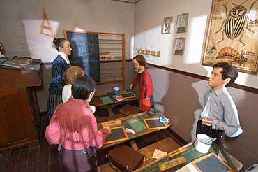 Szene in der Ausstellung: Klassenzimmer um 1947. Die Schler haben neben der Schiefertafel auch einen Becher fr die Schulspeisung auf dem Pult stehen