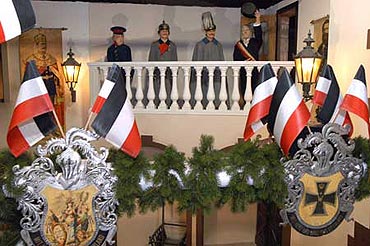 Szene in der Ausstellung: Kaiser Wilhelm II. steht auf einer mit Fahnen geschmückten Empore