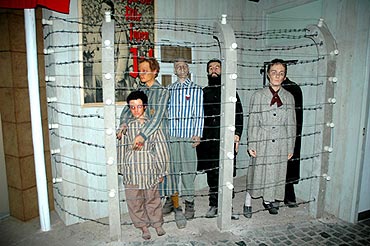 Szene in der Ausstellung: Insassen eines Konzentrationslagers hinter einem Stacheldrahtzaun