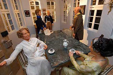 Szene in der Ausstellung: Eine Familie in einem Patrizierhaus um einen Tisch versammelt