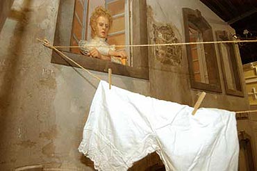 Szene in der Ausstellung: Fassade eines Arbeiterwohnhauses. Eine Prostituierte schaut aus dem Fenster, zwischen den Husern sind Wscheleinen gespannt